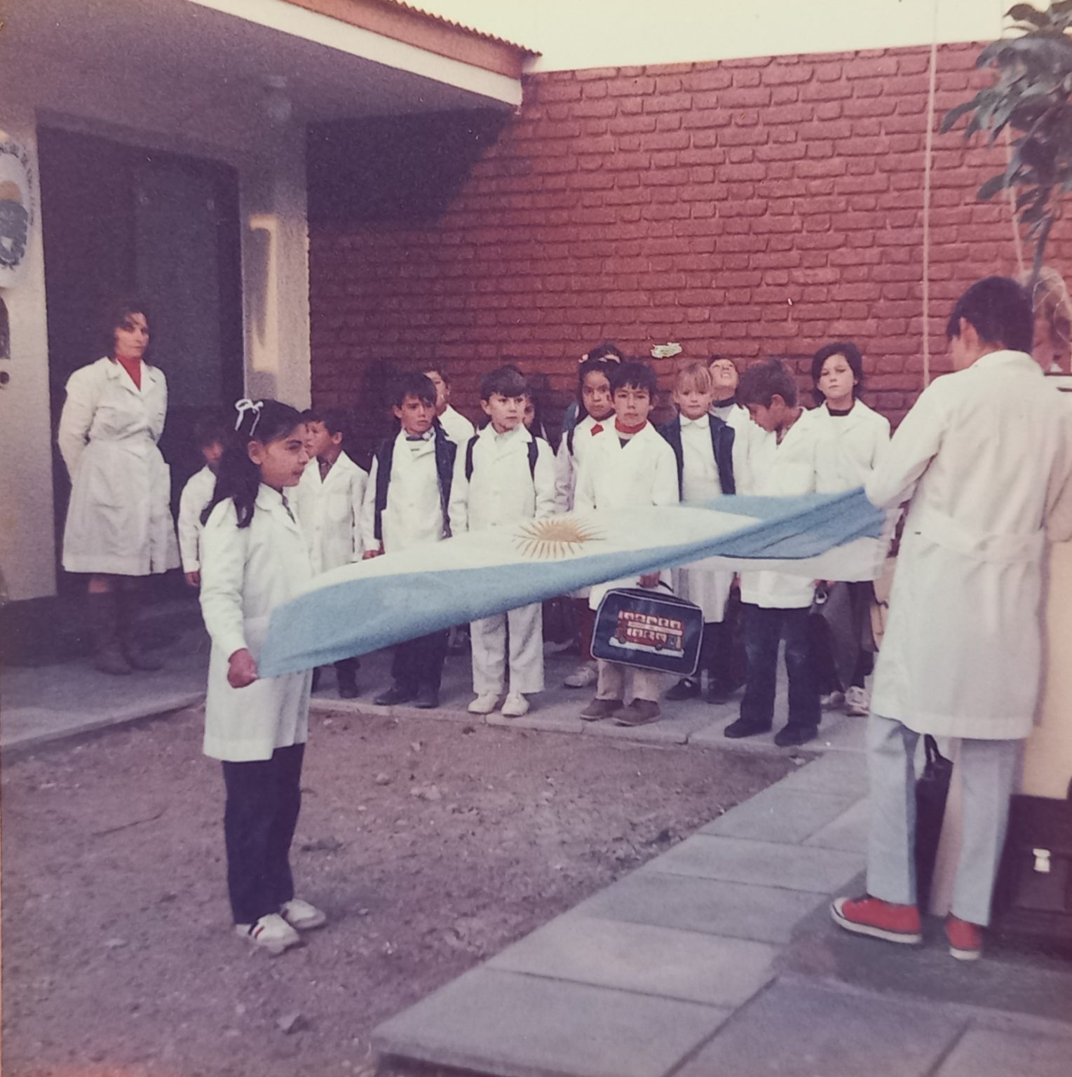Formacion e izado de bandera puerta de escuela. Decada 80. Foto de Norma Idiarte